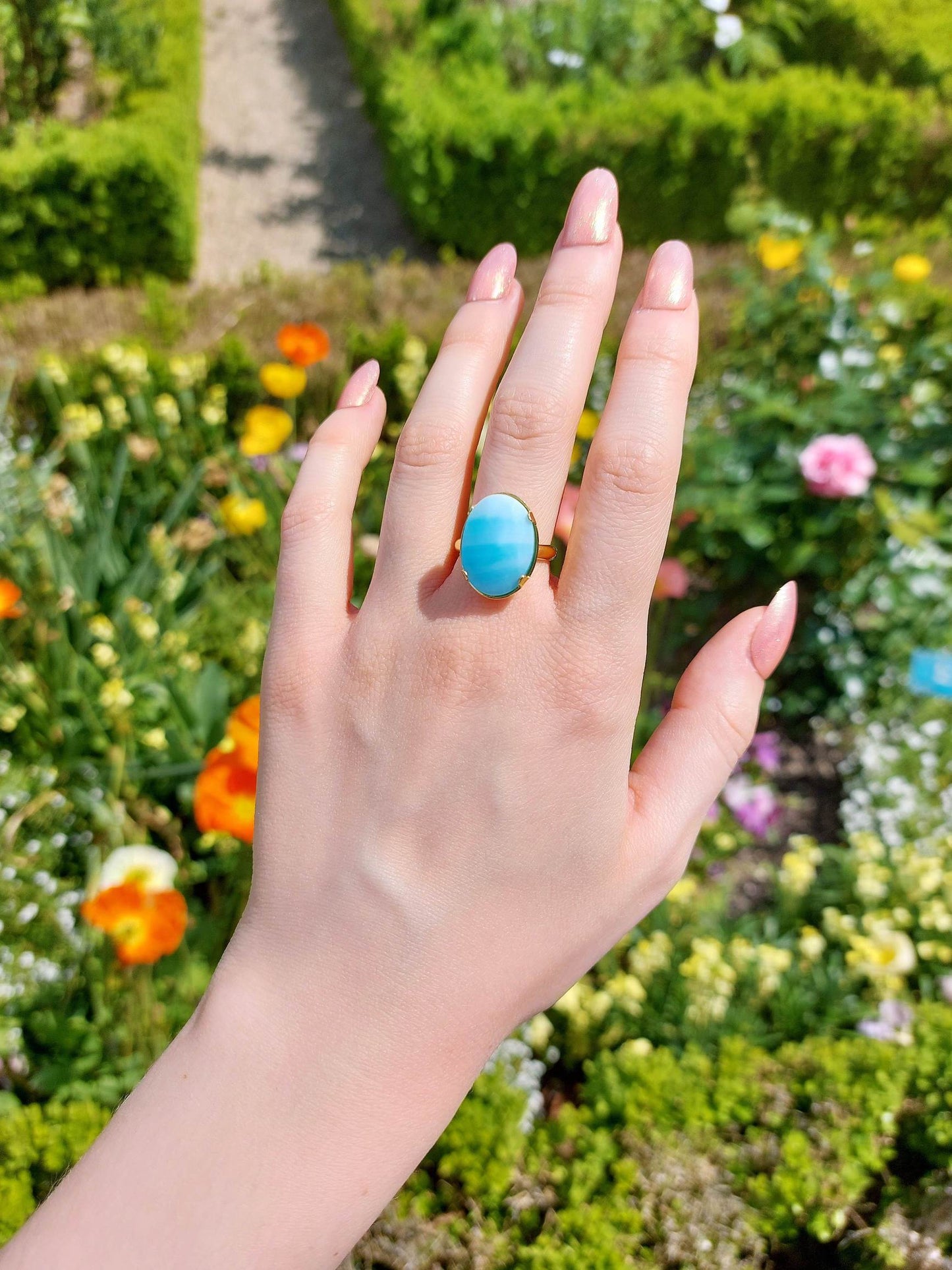 Adjustable gold ring with blue cabochon